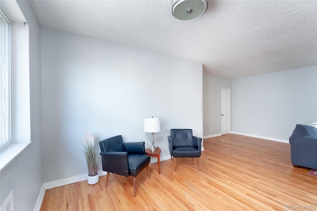 living area featuring hardwood / wood-style floors and a textured ceiling