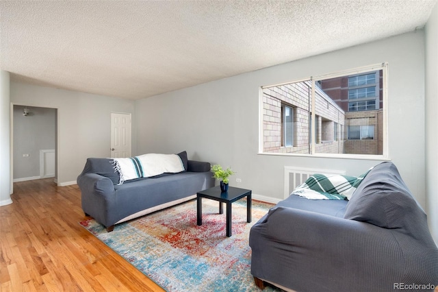 living room with hardwood / wood-style flooring and a textured ceiling