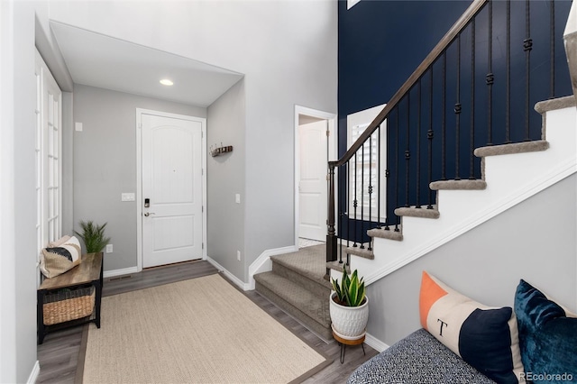 foyer with recessed lighting, stairway, baseboards, and wood finished floors