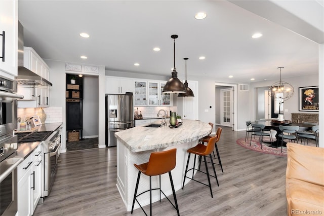 kitchen featuring glass insert cabinets, a sink, appliances with stainless steel finishes, recessed lighting, and decorative backsplash