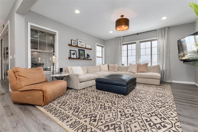 living room with recessed lighting, baseboards, and wood finished floors