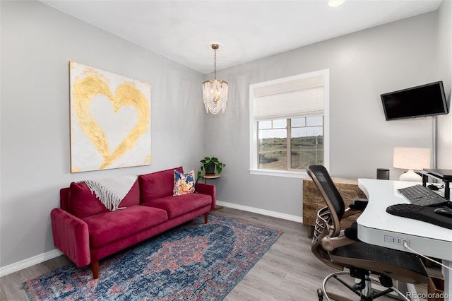 office area with baseboards, an inviting chandelier, and wood finished floors