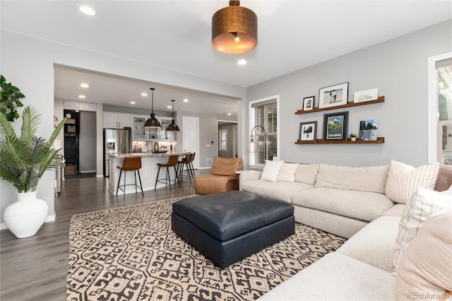 living area featuring baseboards, dark wood-style floors, and recessed lighting