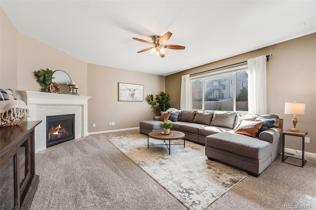 living room with carpet, a fireplace, baseboards, and a ceiling fan