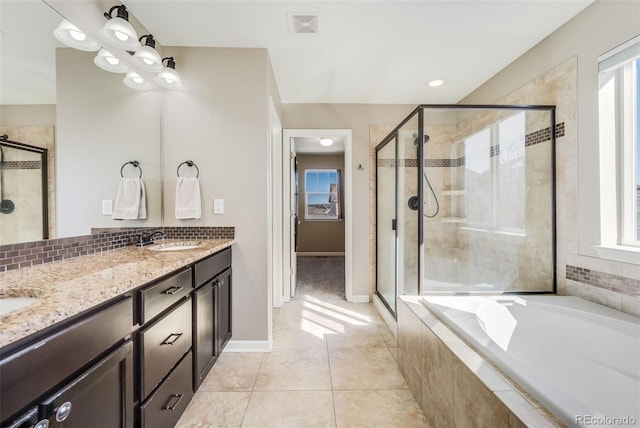 bathroom with a healthy amount of sunlight, a stall shower, a garden tub, and a sink