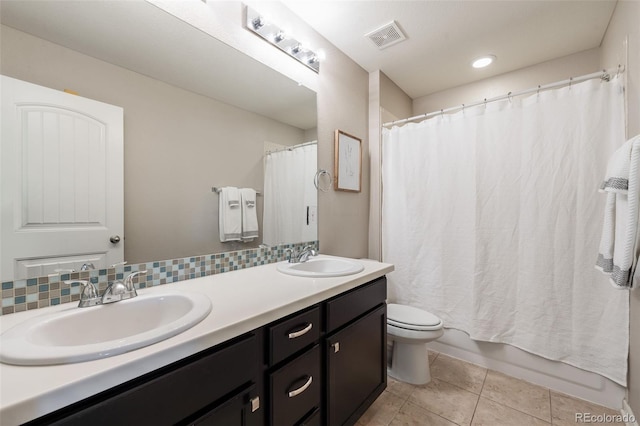 full bathroom with tile patterned floors, double vanity, toilet, and a sink