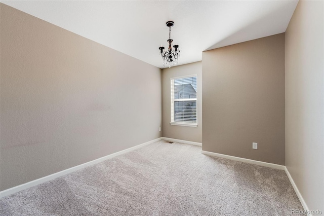 unfurnished room featuring baseboards, light carpet, and an inviting chandelier