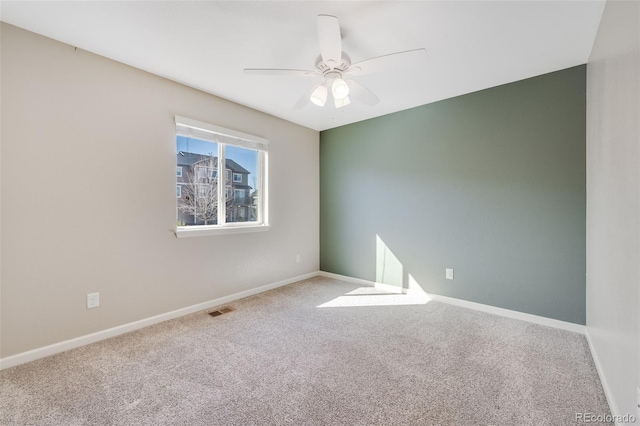 spare room featuring visible vents, baseboards, carpet, and a ceiling fan