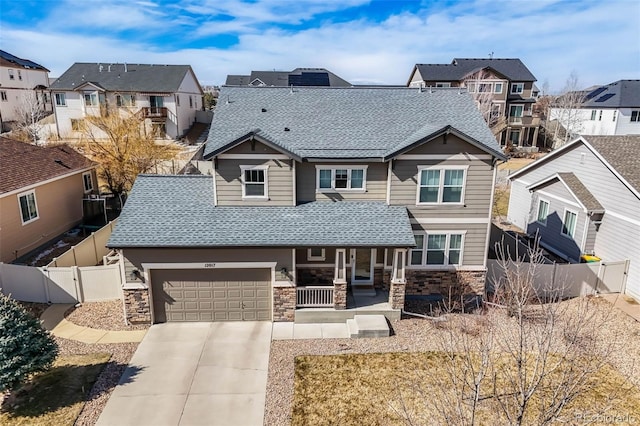 craftsman-style house with a residential view, a porch, a fenced backyard, and a gate