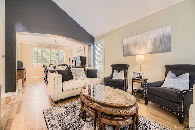 8657 Aberdeen Cir, Highlands Ranch, CO 80130 - living area featuring arched walkways, a chandelier, light wood-style floors, lofted ceiling, and ornamental molding