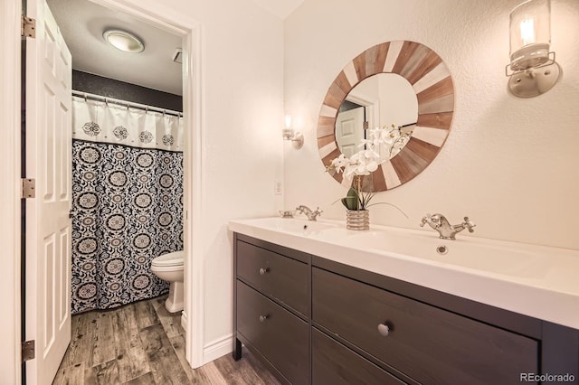 8657 Aberdeen Cir, Highlands Ranch, CO 80130 - bathroom featuring toilet, wood finished floors, and double vanity