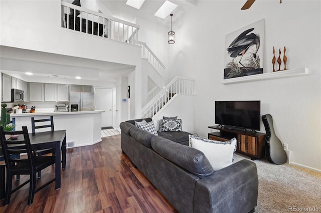 5875 W Asbury Pl, Lakewood, CO 80227 - living room featuring a towering ceiling, a toaster, baseboards, stairway, and dark wood finished floors