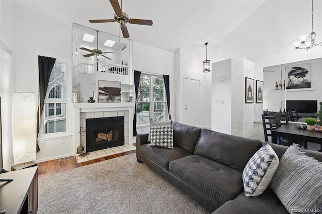 5875 W Asbury Pl, Lakewood, CO 80227 - living area with a tiled fireplace, ceiling fan, wood finished floors, and high vaulted ceiling