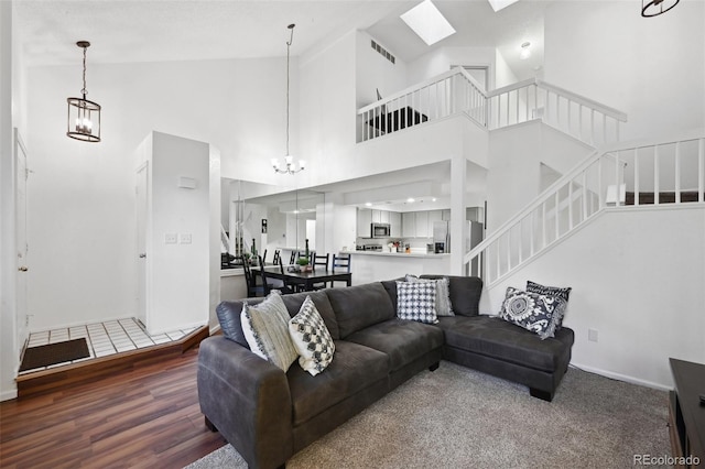 5875 W Asbury Pl, Lakewood, CO 80227 - living area featuring visible vents, wood finished floors, stairway, high vaulted ceiling, and an inviting chandelier