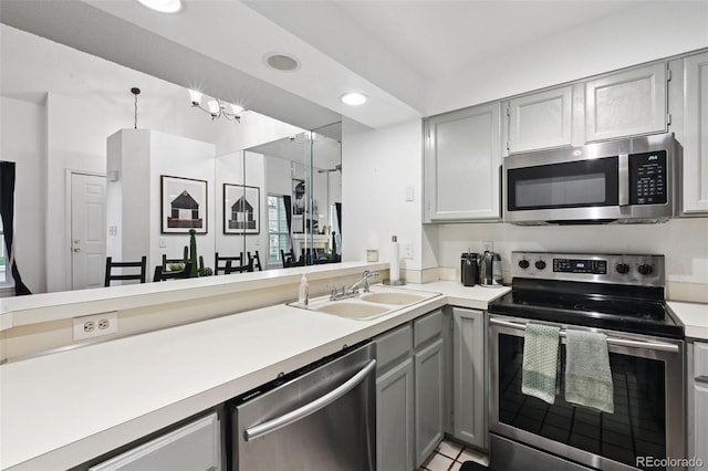 5875 W Asbury Pl, Lakewood, CO 80227 - kitchen featuring a sink, light countertops, gray cabinets, and stainless steel appliances
