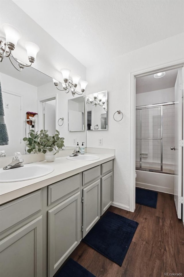 5875 W Asbury Pl, Lakewood, CO 80227 - full bathroom featuring double vanity, a sink, wood finished floors, and a chandelier