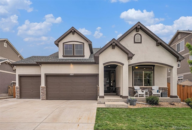 11511 E 118th Ave, Commerce City, CO 80640 - french country style house featuring stucco siding, stone siding, a porch, and driveway
