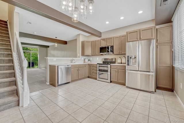 2943 W Riverwalk Cir Unit I, Littleton, CO 80123 - kitchen featuring stainless steel appliances, light tile patterned flooring, beamed ceiling, light countertops, and a peninsula