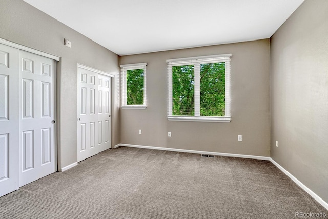 2943 W Riverwalk Cir Unit I, Littleton, CO 80123 - unfurnished bedroom with two closets and carpet