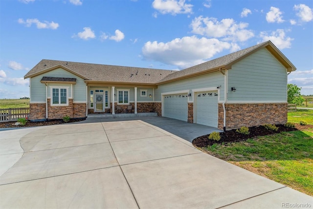 527 Antelope Dr E, Bennett, CO 80102 - view of front facade with an attached garage, concrete driveway, and stone siding