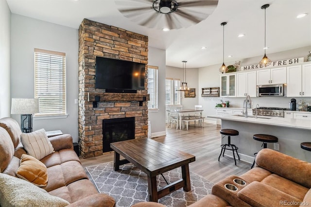 527 Antelope Dr E, Bennett, CO 80102 - living room featuring a ceiling fan, healthy amount of natural light, light wood-style flooring, baseboards, and recessed lighting