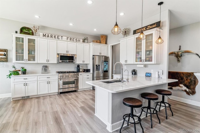 527 Antelope Dr E, Bennett, CO 80102 - kitchen with stainless steel appliances, a sink, a peninsula, white cabinets, and a breakfast bar area