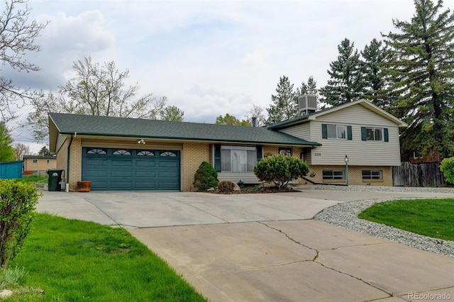 11310 W Center Ave, Lakewood, CO 80226 - tri-level home with brick siding, concrete driveway, central AC, and an attached garage