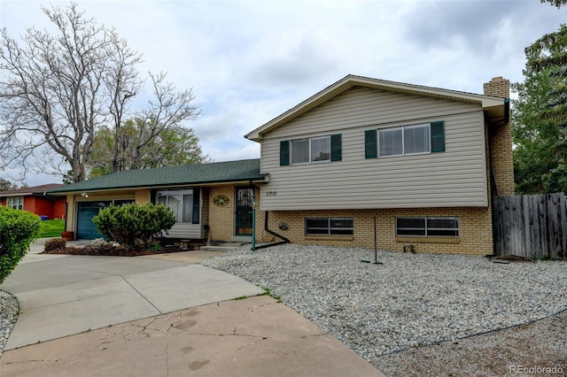 11310 W Center Ave, Lakewood, CO 80226 - tri-level home featuring fence, a chimney, and brick siding