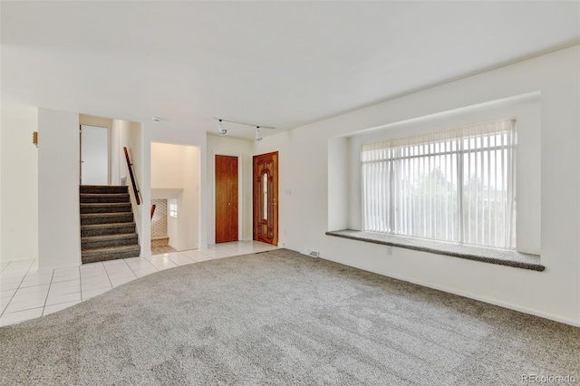 11310 W Center Ave, Lakewood, CO 80226 - unfurnished living room featuring tile patterned flooring, stairs, rail lighting, and carpet
