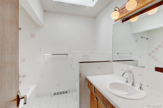 11310 W Center Ave, Lakewood, CO 80226 - full bath featuring tile patterned flooring, toilet, tile walls, vanity, and a skylight
