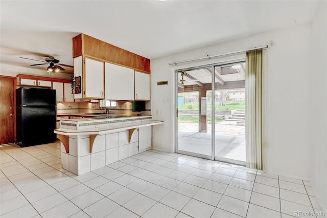 11310 W Center Ave, Lakewood, CO 80226 - kitchen featuring freestanding refrigerator, light countertops, a ceiling fan, light tile patterned flooring, and white cabinets