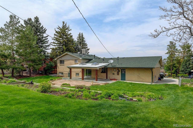 11310 W Center Ave, Lakewood, CO 80226 - back of house featuring a patio area, a lawn, and brick siding