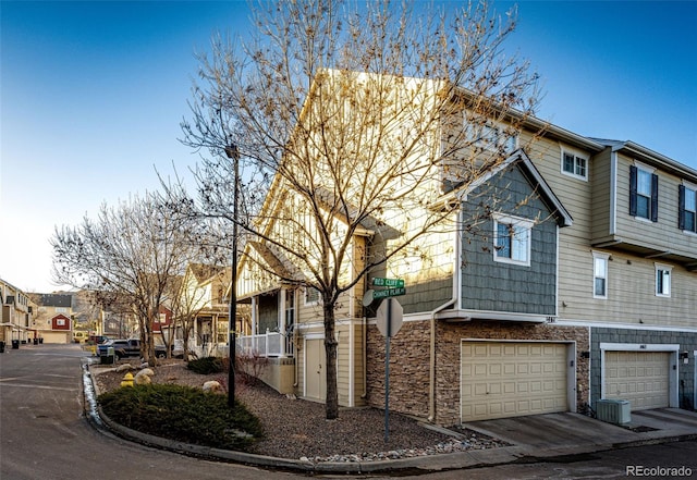 view of front of home with a garage and central air condition unit