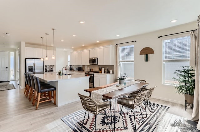 dining space with recessed lighting and light wood-style floors