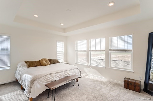 carpeted bedroom with a tray ceiling, baseboards, and recessed lighting
