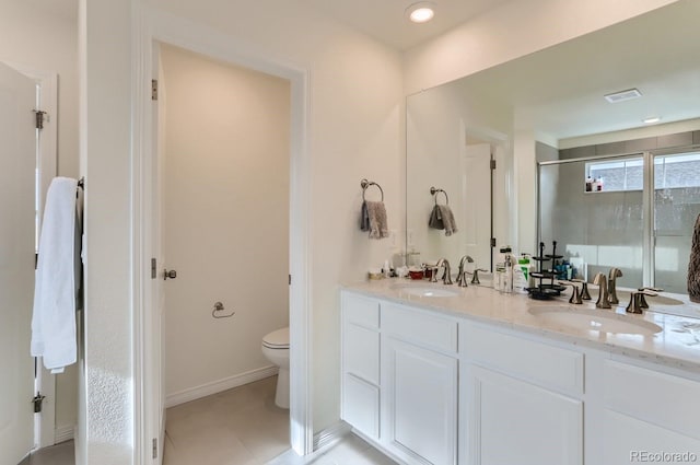 full bath featuring double vanity, toilet, a stall shower, and a sink