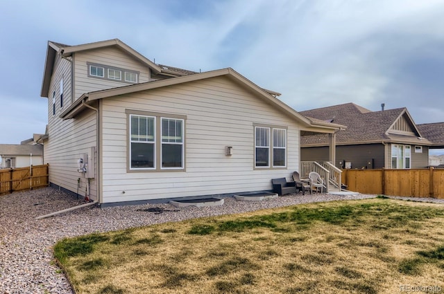 rear view of house featuring a fenced backyard and a yard
