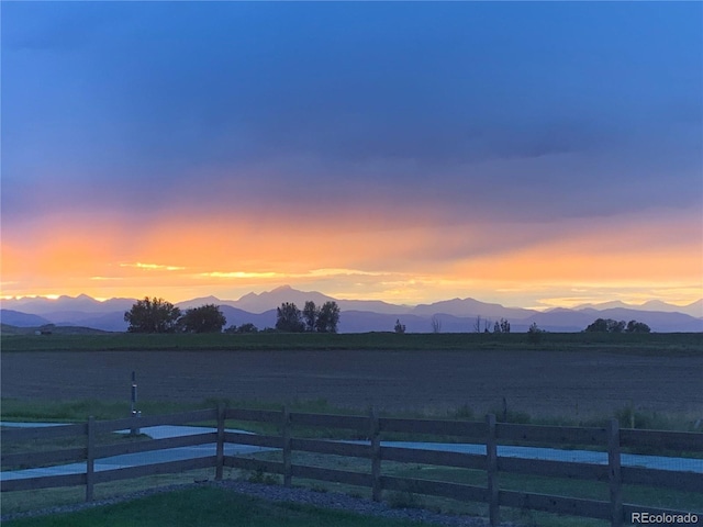 yard at dusk with fence and a mountain view