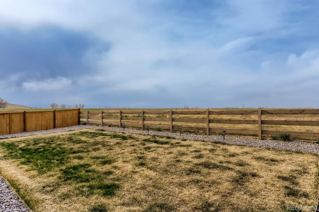 view of yard with a rural view and a fenced backyard