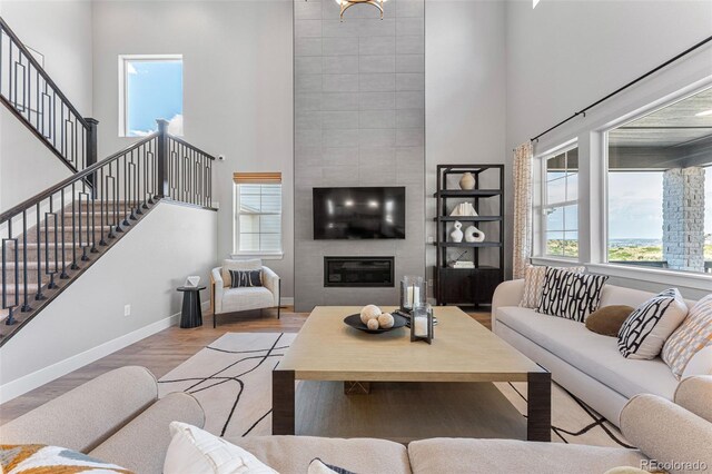 16565 Black Rose Cir, Parker, CO 80134 - living area with a high ceiling, baseboards, stairway, wood finished floors, and a large fireplace