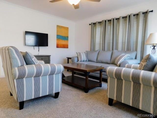 carpeted living room with ceiling fan