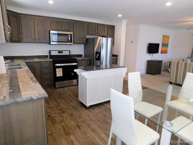 kitchen featuring sink, dark hardwood / wood-style floors, stainless steel appliances, and dark brown cabinets