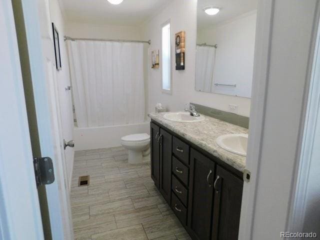 full bathroom featuring dual vanity, toilet, tile patterned floors, and shower / bath combo