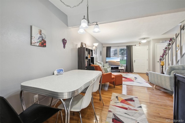 dining space featuring light hardwood / wood-style floors and lofted ceiling