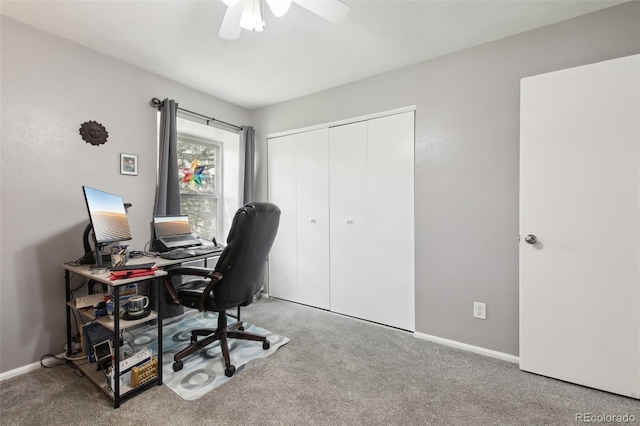 carpeted office space featuring ceiling fan