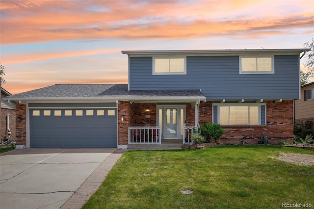 8732 W Arbor Ave, Littleton, CO 80123 - traditional-style house with brick siding, a front yard, an attached garage, and driveway