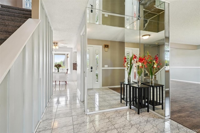 8732 W Arbor Ave, Littleton, CO 80123 - entrance foyer with marble finish flooring, a textured ceiling, a ceiling fan, a high ceiling, and stairs