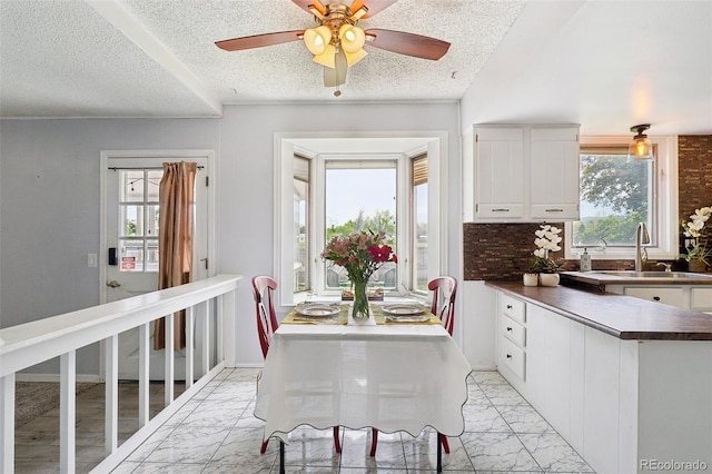8732 W Arbor Ave, Littleton, CO 80123 - dining space with light marble finish flooring, a textured ceiling, and ceiling fan