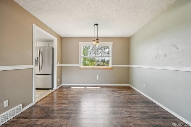 8732 W Arbor Ave, Littleton, CO 80123 - unfurnished dining area with wood finished floors and a textured ceiling
