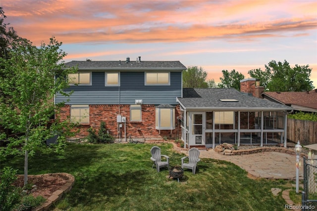 8732 W Arbor Ave, Littleton, CO 80123 - back of property at dusk featuring a sunroom, brick siding, and a chimney